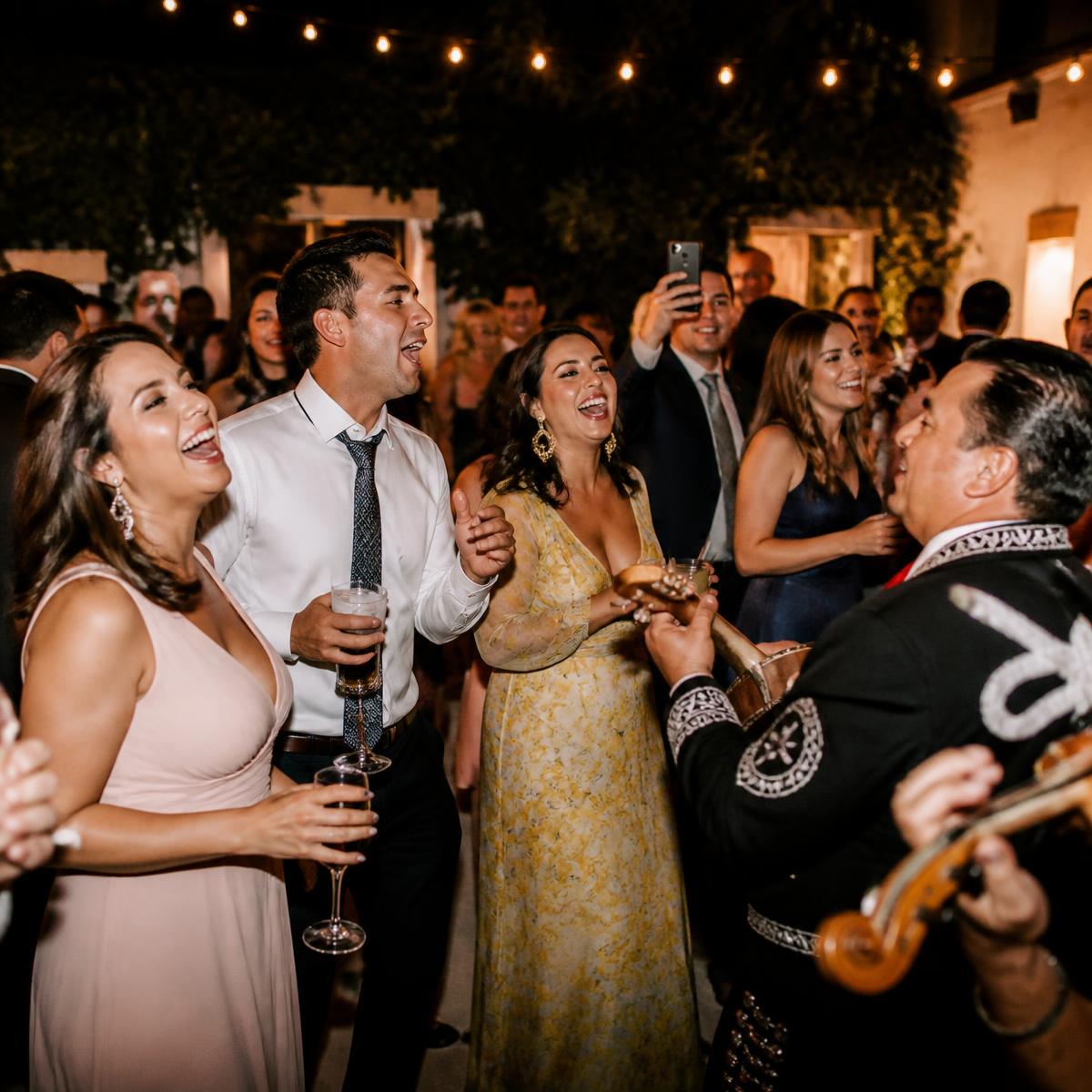 Invitados cantando y disfrutando de la música en una fiesta nocturna.